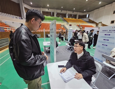 招聘企业正在向毕业生介绍公司人才培养计划。